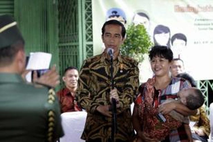 Presiden Joko Widodo berfoto bersama warga saat menghadiri penyerahan Kartu Indonesia Sehat (KIS), Kartu Indonesia Pintar (KIP), dan Kartu Keluarga Sejahtera (KKS) di Kantor Pos Kampung Melayu, Jalan Jatinegara Barat, Jakarta Timur, Rabu (13/5/2015).