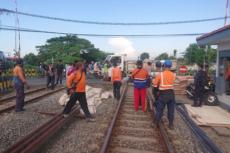 Petugas melakukan evakuasi truk yang terperosok di perlintasan rel kereta api yang berada di Kecamatan Cerme, Gresik, Selasa (21/6/2022). *** Local Caption *** Petugas melakukan evakuasi truk yang terperosok di perlintasan rel kereta api yang berada di Kecamatan Cerme, Gresik, Selasa (21/6/2022).
