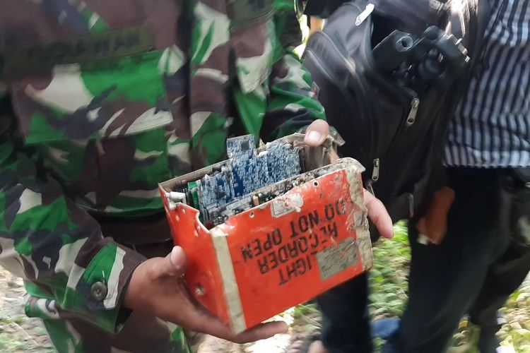 Anggota TNI membawa kotak berwarna oranye yang diduga blackbox Pesawat tempur T-50i Golden Eagle yang terjatuh di Desa Nginggil, Kecamatan Kradenan, Kabupaten Blora, Jawa Tengah, Selasa (19/7/2022)