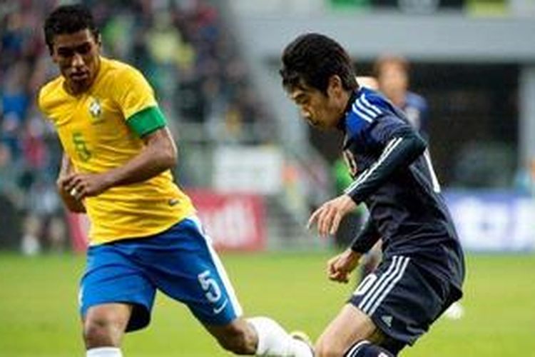 Gelandang Brasil, Paulinho (kiri), tengah memperhatikan penyerang Jepang, Shinji Kagawa, dalam laga uji coba di Stadion Municipal, Wroclaw, Polandia, Selasa (16/10/2012). Brasil akhirnya menang 4-0. 