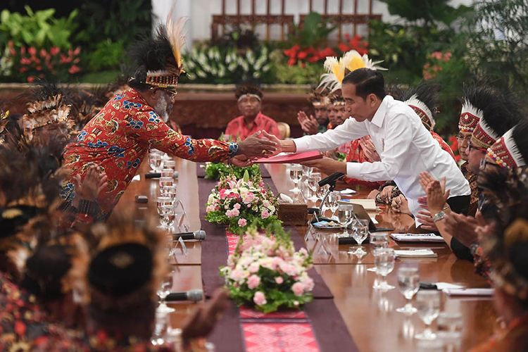 Presiden Joko Widodo (kanan) menerima map berisi saran dari perwakilan tokoh Papua Abisai Rollo (kiri) dalam pertemuan di Istana Negara, Jakarta, Selasa (10/9/2019). Pertemuan tersebut membahas isu-isu terkini di Papua.