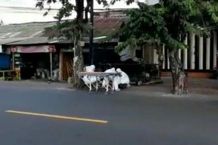 Petugas dari rumah sakit memakai APD saat evakuasi seorang WNA yang diduga sakit dan tak sadarkan diri di pinggir jalan.