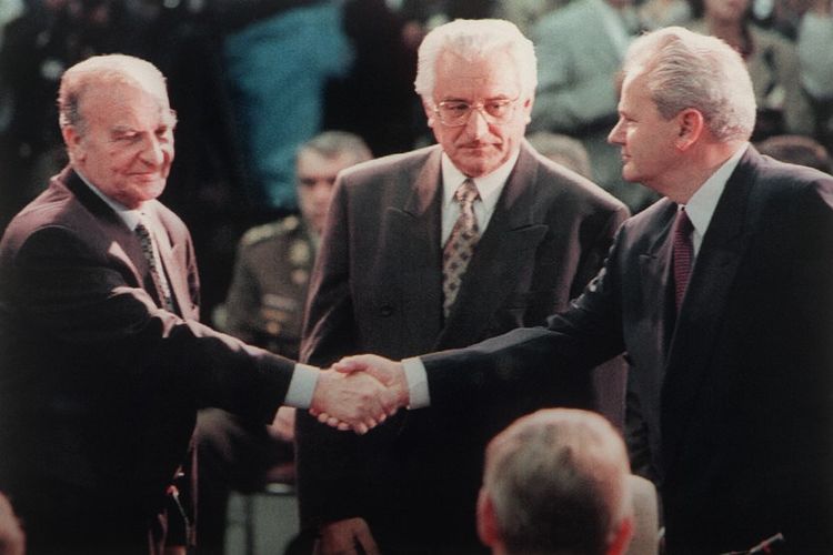 Presiden Bosnia Alija Izetbegovic (kiri) menyalami Presiden Serbia Slobodan Milosevic disaksikan Presiden Kroasia Franjo Tudjman menjelang pembicaraan damai di Dayton, Ohio, AS pada 1995.
