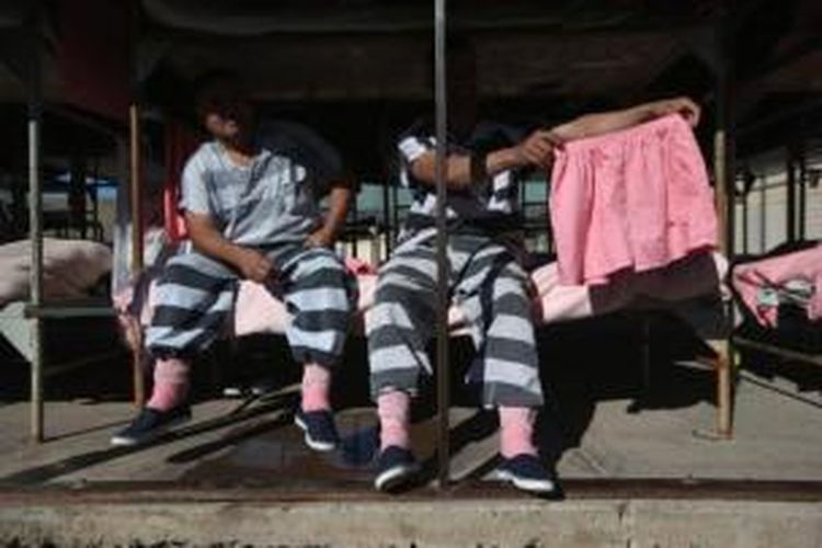 Foto ini diambil pada 11 Maret 2013, menampilkan dua orang narapidana di AS memamerkan pakaian tahanan berwarna merah muda. Pemerintah Queensland, Australia mempertimbangkan baju berwarna merah muda ini untuk mempermalukan tahanan khususnya para anggota geng motor.