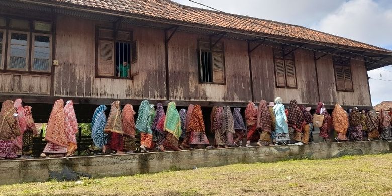 Para perempuan sedang mengenakan Tudung Lingkup sedang pawai dalam Festival Tudung Lingkup, Minggu (28/8/2022).