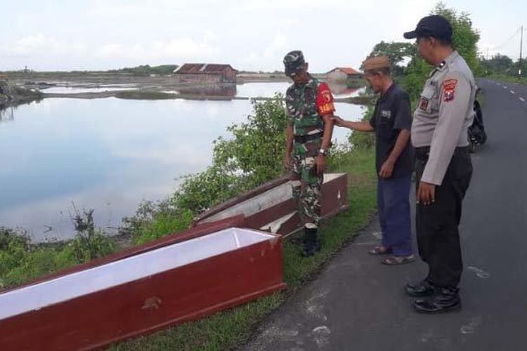 Babinsa dan Bhabinkamtibas Desa Beddurih, Padewamu, Pamekasan, Madura, saat mengecek penemuan dua peti jenazah yang tergeletak di pinggir tambak, Selasa (17/3/2020).

