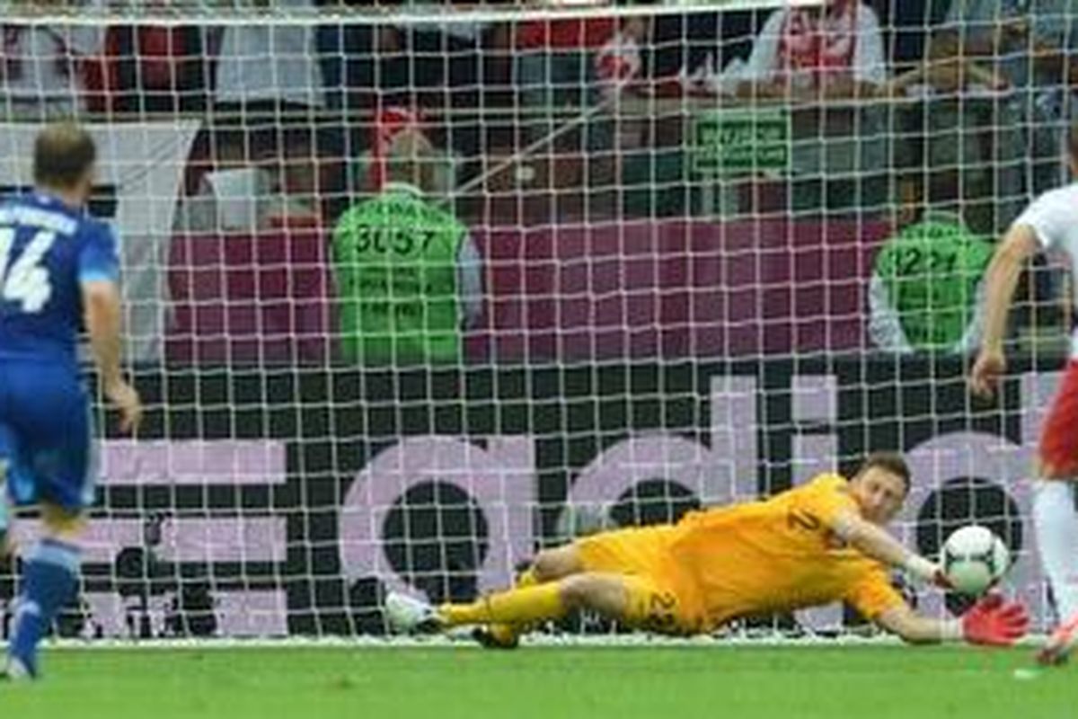 Kiper Polandia, Przemyslaw Tyton, menepis tembakan penalti pemain Yunani, Giorgos Karagounis, pada laga perdana Piala Eropa 2012, di Stadion Nasional Warsawa, Jumat (8/6/2012).