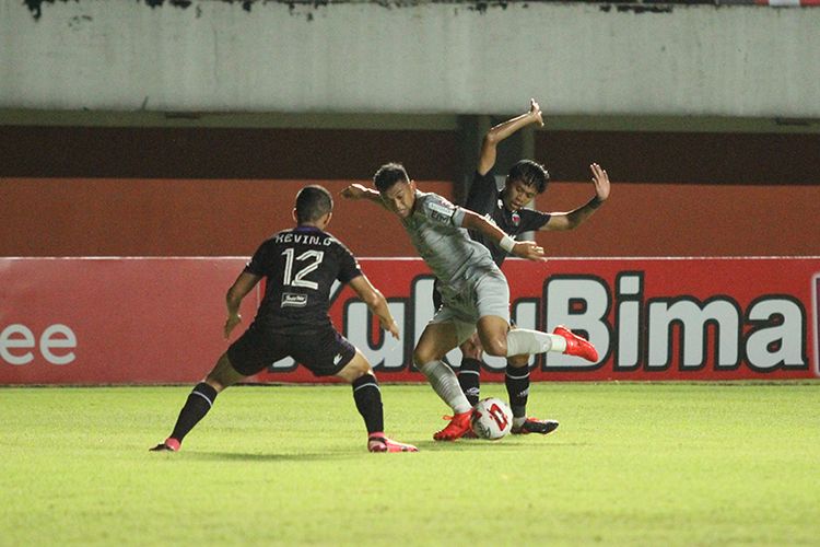 Gelandang Persib Bandung, Abdul Aziz Lufti Akbar (abu-abu) pergerakannya coba dihentikan oleh dua pemain Persita Tangerang saat kedua tim bertemu di Stadion Maguwoharjo, Sleman, Senin (29/03/2021). 