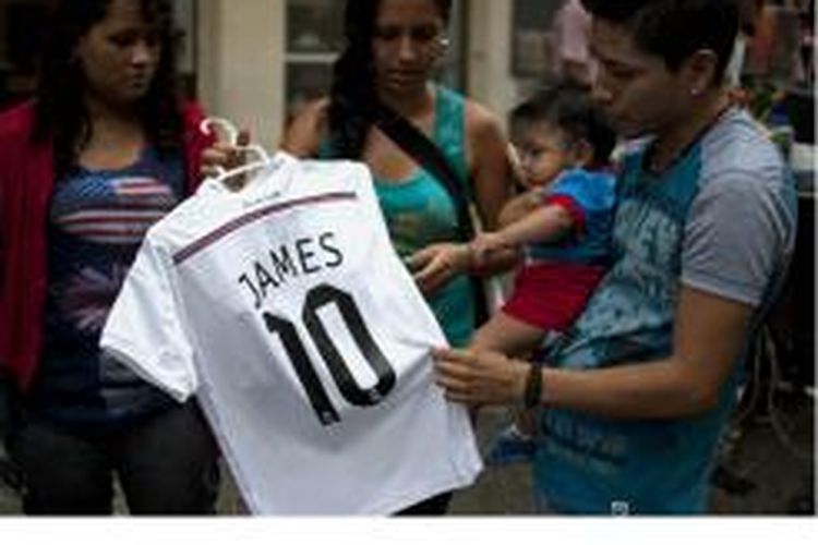 Orang sedang melihat jersey Real Madrid bertuliskan nama James Rodriguez, striker timnas Kolombia yang kini menjadi pemain baru Real Madrid. Jersey itu dijual di ae street of Cali, department of Valle del Cauca, Kolombia, 23 Juli 2014.