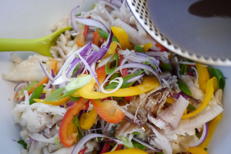 Salad ceker ayam  khas Laos Yum Tien Gai dituangi kecap ikan.