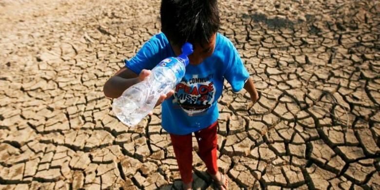 Mamat (10) mencuci muka untuk mengusir panas dari botol bekal air minumnya saat bermain di sekitar kolam salah satu sumber air untuk warga Kampung Campaka, Desa Cihampelas, Kabupaten Bandung Barat, Jawa Barat, yang mengering, Rabu (29/7). Sejak sebulan terakhir, debit air kolam tersebut terus menyusut hingga pada akhirnya kering saat musim kemarau ini. Mengeringnya kolam dan menyusutnya debit air sejumlah sumber air bersih dirasakan menyulitkan warga.