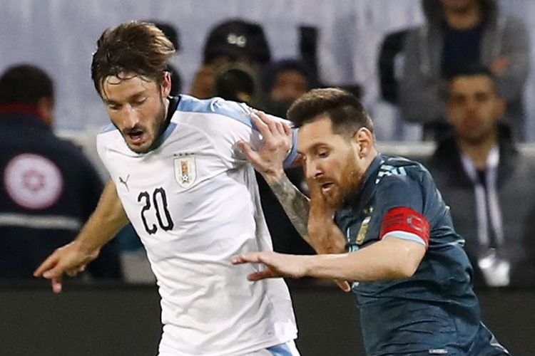 Martin Caceres (kiri) mengawal Lionel Messi pada pertandingan persahabatan internasional, Argentina vs Uruguay, di Tel Aviv, 18 November 2019. 