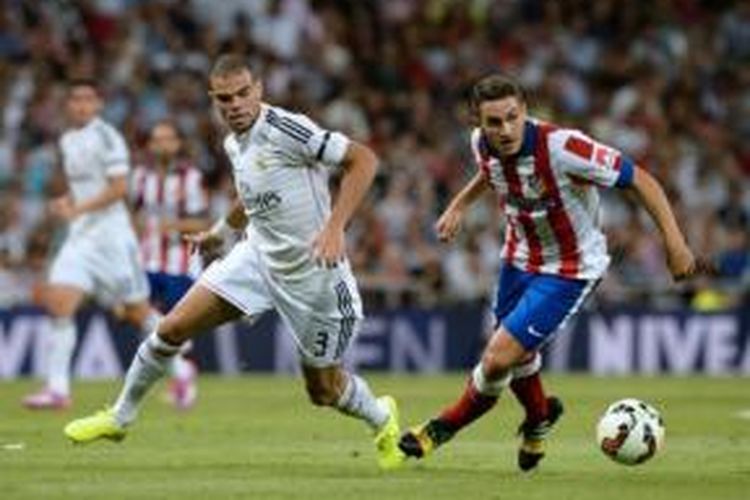 Bek Real Madrid, Pepe (kiri), mengawal gelandang Atletico Madrid, Koke (kanan), pada laga Primera Division di Santiago Bernabeu, Madrid, Sabtu (13/9/2014).