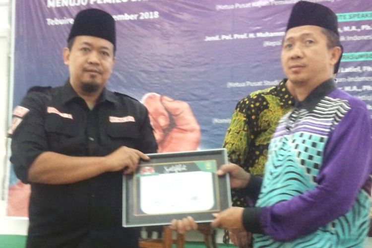 Anggota Komisi Pemilihan Umum (KPU) Jawa Timur, Gogot Cahyo Baskoro (kiri), menerima cinderamata dari Ketua Pusat Kajian Pemikiran KH. Hasyim Asyari Pesantren Tebuireng, setelah tampil sebagai pembicara dalam Seminar Nasional, di Pesantren Tebuireng Jombang, Minggu (11/11/2018).