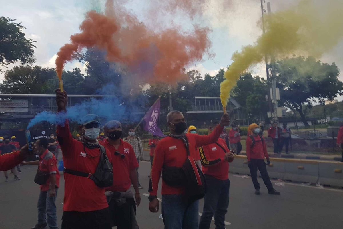 Workers from the KASBI Labor Association fire multicolored smoke bombs and flares to signify the end of May Day protests on Saturday (1/5/2021).