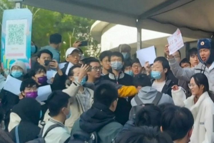 Tangkapan bingkai dari rekaman video yang tersedia melalui AFPTV pada 27 November 2022 ini menunjukkan para mahasiswa memprotes kebijakan nol-Covid China di Universitas Tsinghua di Beijing. 