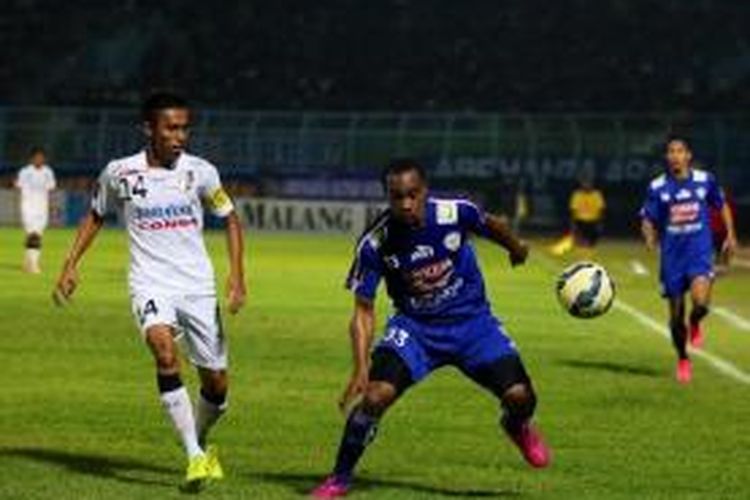 Penyerang Arema Cronus, Lancine Kone (kanan), dibayang-bayangi oleh pemain Bali United, Fadil Sausu, pada leg pertama Piala Presiden 2015 di Stadion Kanjuruhan, Malang, Sabtu (19/9/2015).