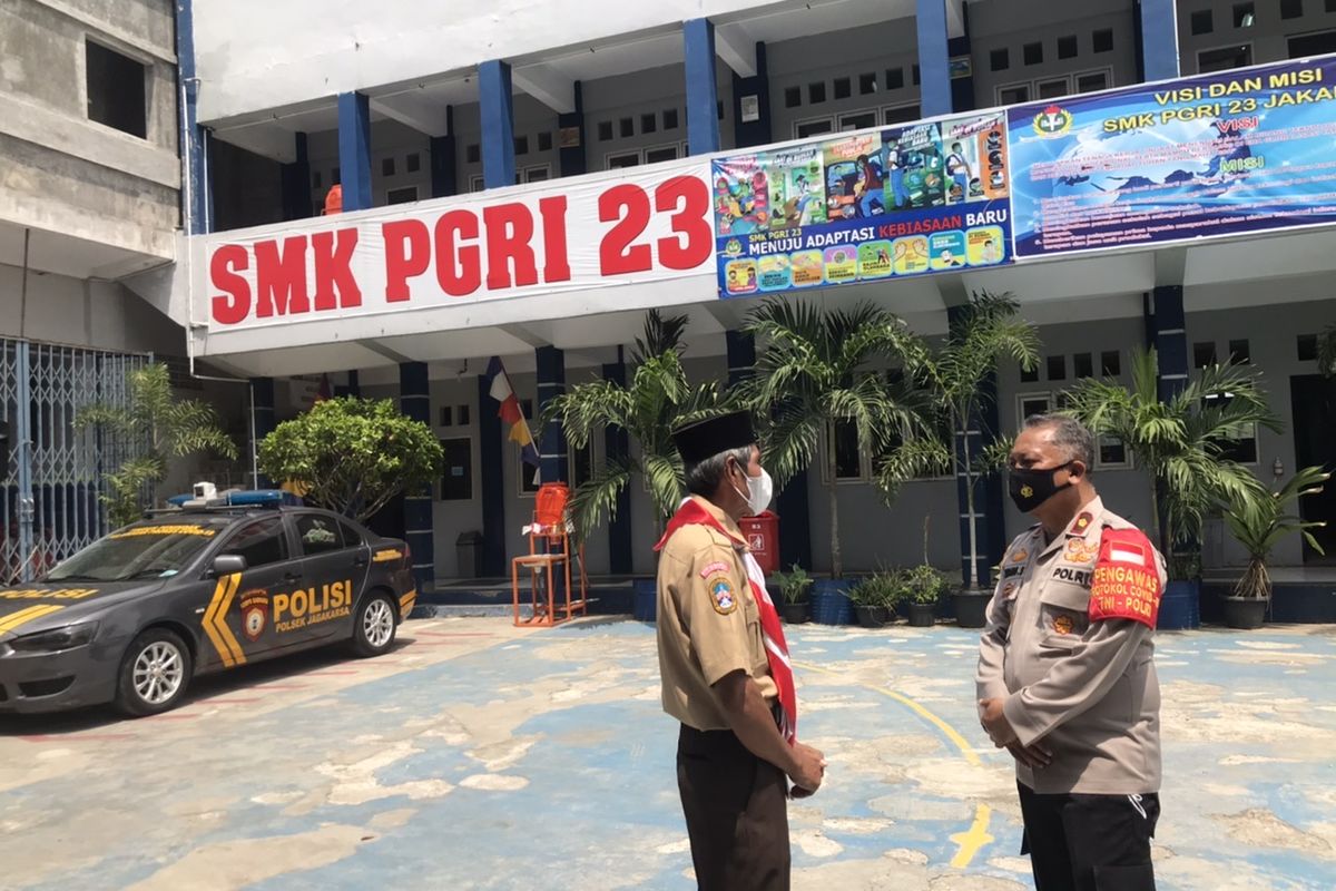 Kepala Sekolah SMK PGRI 23 Srengseng Sawah, Mansur S. berbincang dengan Kapolsek Jagakarsa Kompol Endang Sukmawijaya di SMK PGRI 23, Rabu (6/10/2021) siang.