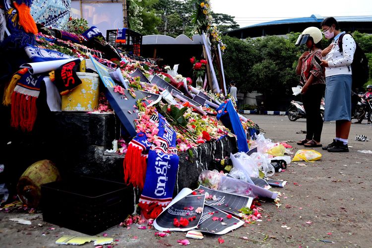Dua orang perempuan berdoa di monumen Singo Tegar tepat di hari kedua pasca tragedi yang terjadi pada pekan ke-11 Liga 1 2022-2023 seusai pertandingan bertajuk Derbi Jawa Timur, Arema FC melawan Persebaya Surabaya di Stadion Kanjuruhan Kepanjen, Kabupaten Malang, Senin (3/10/2022) siang.