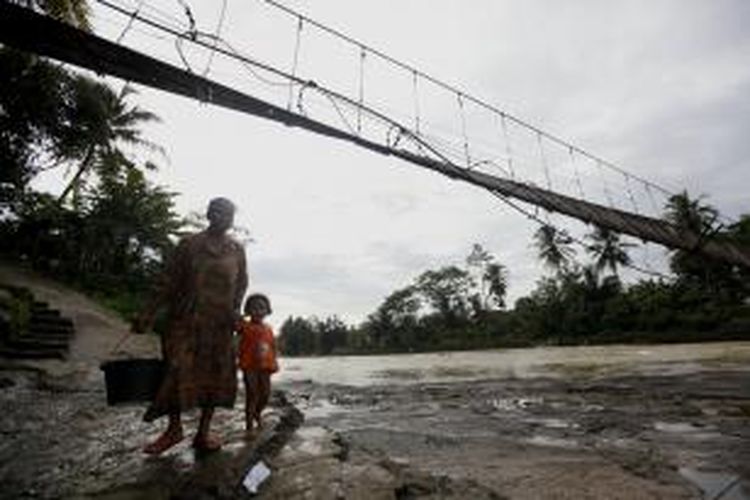 Jembatan gantung di Desa Sukajaya, Kecamatan Sajira, Kabupaten Lebak, Banten, rusak hingga tak bisa dipergunakan warga, Kamis (9/1/2014). Kawat besi jembatan yang pernah diperbaiki tahun 2011 putus dan mengakibatkan aktivitas warga terutama anak-anak sekolah dan petani terhambat. Saat air sungai Ciberang surut, warga berjalan kaki menyeberangi sungai, namun saat debit sungai meningkat mereka harus memutar jalan yang lebih jauh. KOMPAS/LUCKY PRANSISKA 