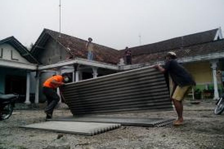 Warga di Desa Sugihwaras, Kecamatan Ngancar, Kabupaten Kediri, Jawa Timur, Rabu (19/2/2014), mulai memperbaiki rumahnya yang rusak akibat tertimpa material erupsi Gunung Kelud.