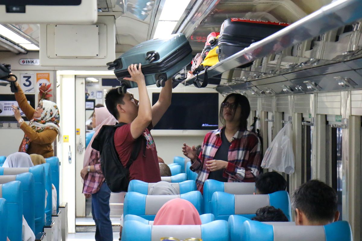 Suasana di dalam gerbong kereta api yang ramai penumpang.