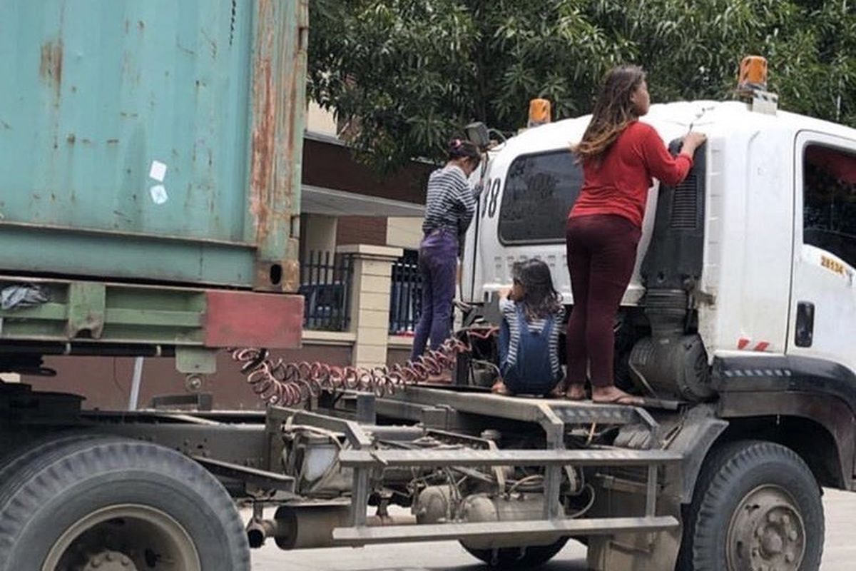 Tiga perempuan nampak menumpang di sambungan truk trailer di sekitar kawasan Tanjung Priok, Jakarta Utara, Senin (25/3/2019). 