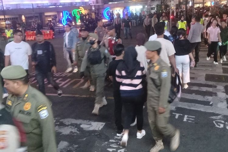 Petugas tengah berpatroli melakukan sosialisasi himbauan jam malam bagi para pelajar agar tak berkeliaran diatas jam 21.00 WIB, di Jalan Asia afrika dan Jalan braga Kota Bandung, Jawa Barat, Selasa (3/6/2025)