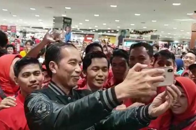 Presiden Joko Widodo membuat vlog dengan kamera ponselnya saat blusukan di Mal Ratu Indah, Kota Makassar, Sulawesi Selatan, Sabtu (22/12/2018).