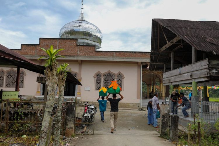 Potret warga membawa makanan ke masjid untuk kenduri maulid. 