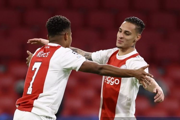 David Neres (kiri) dan Antony (kanan) berselebrasi dalam laga Grup C Liga Champions antara between Ajax Amsterdam and Sporting CP di Johan Cruyff Arena, pada 7 Desember 2021. (Photo by Kenzo Tribouillard / AFP)