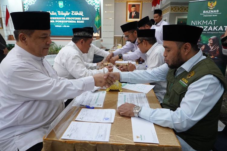 Penjabat (Pj) Gubernur Riau SF Hariyanto saat menyerahkan zakat ke Baznas Riau, Senin (1/4/2024).