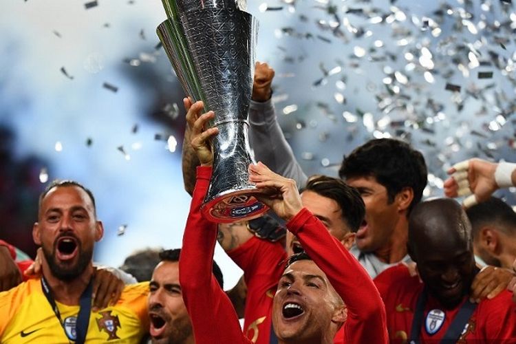 Kapten Portugal Cristiano Ronaldo mengangkat trofi saat ia merayakan gelar juara dengan rekan setimnya setelah pertandingan final UEFA Nations League antara Portugal vs Belanda di Stadion Dragao di Porto pada 9 Juni 2019.
