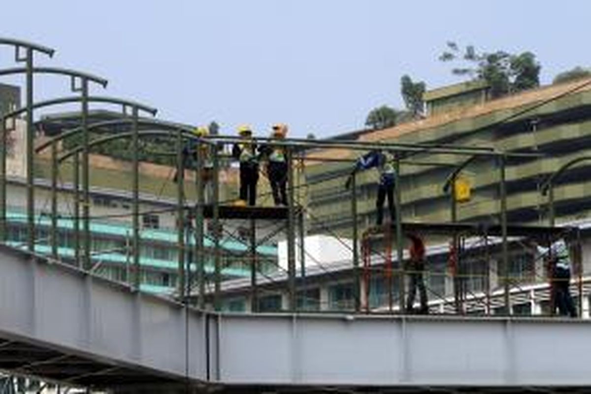 Pekerja menyelesaikan pembangunan jembatan penyeberangan orang (JPO) sementara di sekitar Bundaran Hotel Indonesia (HI), Jakarta Pusat, Jumat (22/8/2014). Pembangunan JPO sementara di depan Plaza Indonesia ini merupakan hasil relokasi dari JPO sebelumnya yang berlokasi di depan Hotel Pullman, akibat dampak dari pembangunan MRT koridor Sisingamangaraja-Sudirman-Bundaran HI yang sedang berlangsung. TRIBUNNEWS/HERUDIN