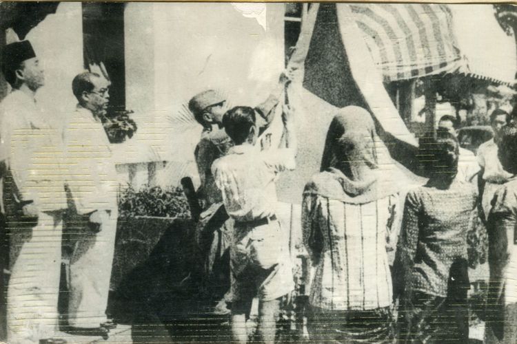 *** Local Caption *** Upacara penaikan bendera sang merah putih di halaman gedung pegangsaan timur 56 (Gedung Proklamasi). Tampak antara lain Bung Karno, Bung Hatta, Let,Kol. Latief Hendraningrat (menaikkan bendera) Ny. Fatmawati Sukarno dan Ny.S.K Trimurti.

A 01 T 1945 H 04