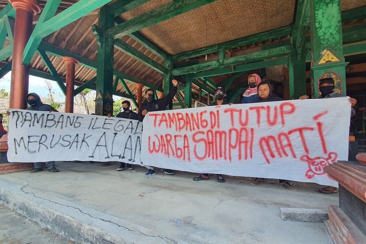 Warga membentangkan tulisan menolak penambangan urug untuk tol di Balai Kalurahan Serut, Gedangsari, Gunungkidul. Senin (2/10/2023)