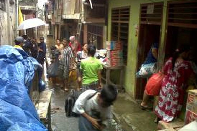 Warga di Gang V, Kampung Pulo, Jatinegara, Jakarta Timur mengemasi barang dari banjir yang mulai merendam kawasan mereka. Jumat (17/1/2014).