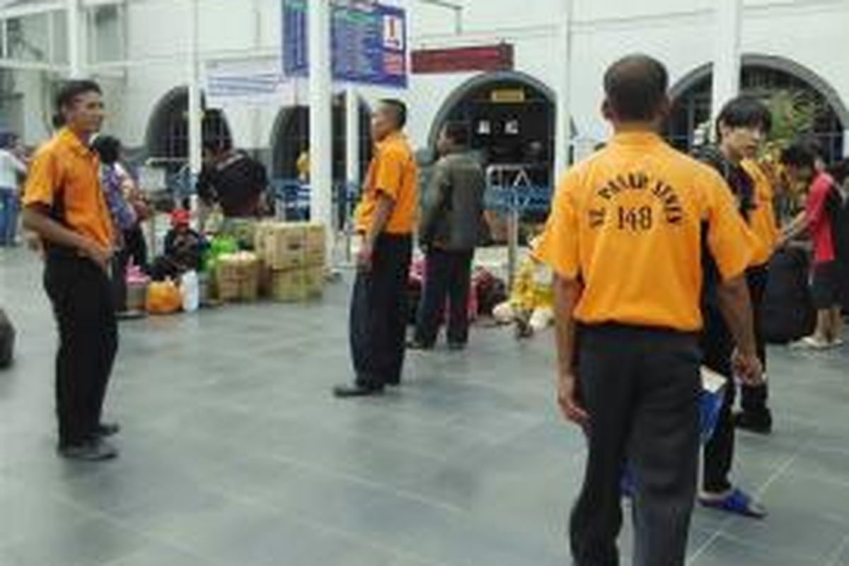 Jasa porter berseragam oranye di Stasiun Pasar Senen kerap dipakai penumpang yang membawa banyak barang saat mudik, Jumat (10/7/2015)