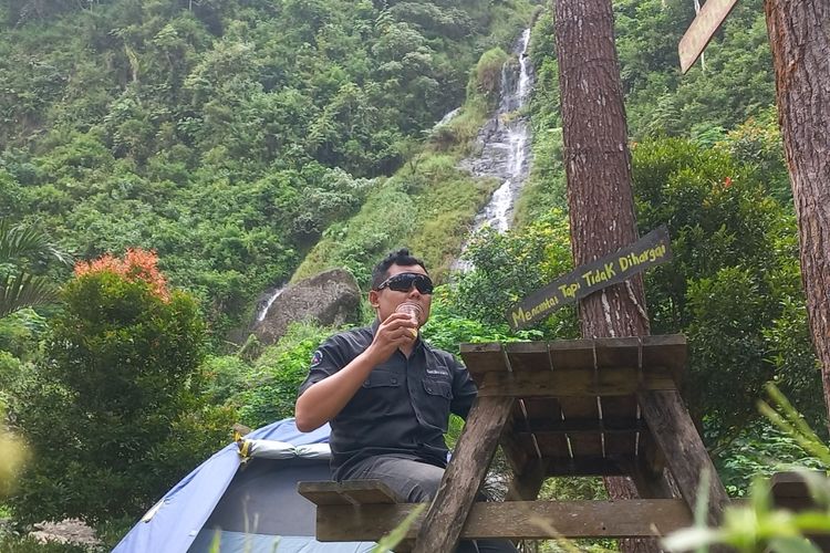 Salah seorang pengunjung sedang menikmati kopi di bawah Curug Gunung Putri Desa Cepedak, Kecamatan Bruno Kabupaten Purworejo Senin (17/6/2024)