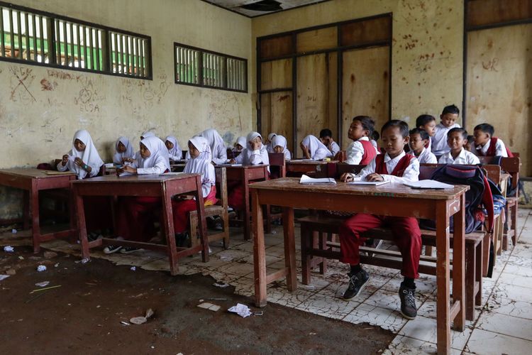 Murid SD Negeri Samudrajaya 04, Kecamatan Tarumajaya, Kabupaten Bekasi belajar di ruang kelas yang rusak, Senin (20/1/2020). Kondisi sekolah yang rusak sejak 2014 ini membuat proses belajar mengajar tidak nyaman.