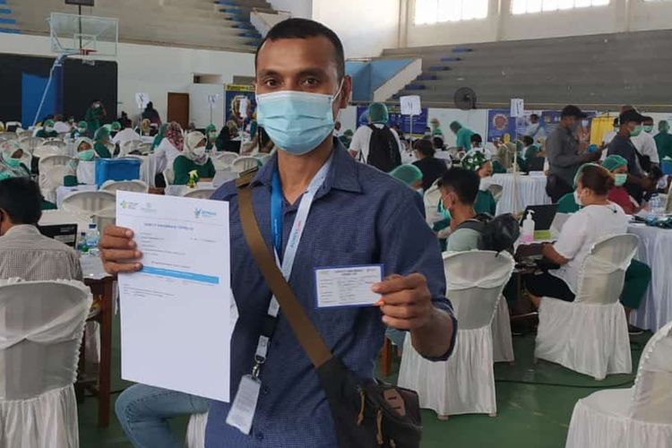 Jurnalis Kompas.com menunjukkan sertifikat vaksin usai menjalani vaksinasi di Sport Hall Karang Panjang Ambon, Rabu (17/3/2021)