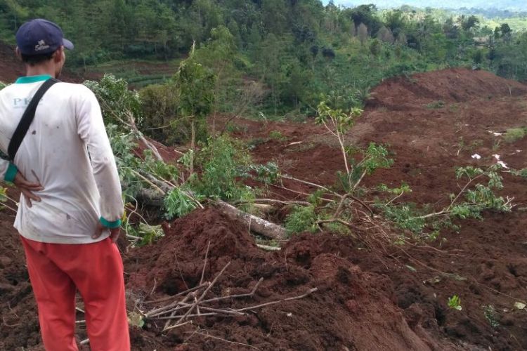 Salah satu relawan memantau lokasi bencana tanah longsor yang menimbun puluhan rumah di Dukuh Tingkil, Desa Banaran, Kecamatan Pulung, Kabupaten Ponorogo, Sabtu ( 1 / 4 / 2017) 