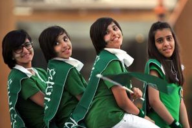 Para remaja putri Arab Saudi ini mengenakan bendera nasional di pundaknya saat merayakan hari jadi kerajaan ke-83, Senin (23/9/2013).