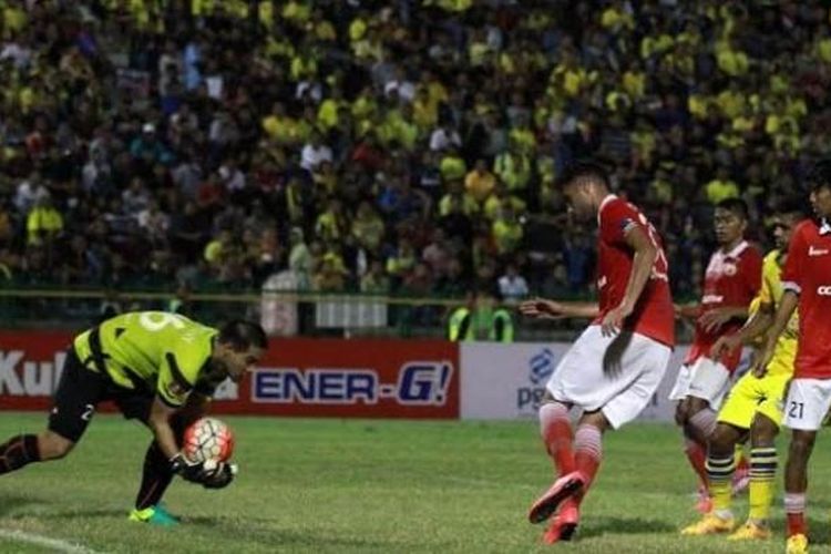 Kiper Persija, Andritany Ardhiyasa mengamankan bola sepakan pemain Persegres di Stadion Tri Dharma, Gresik, Jumat (12/8/2016) malam. 