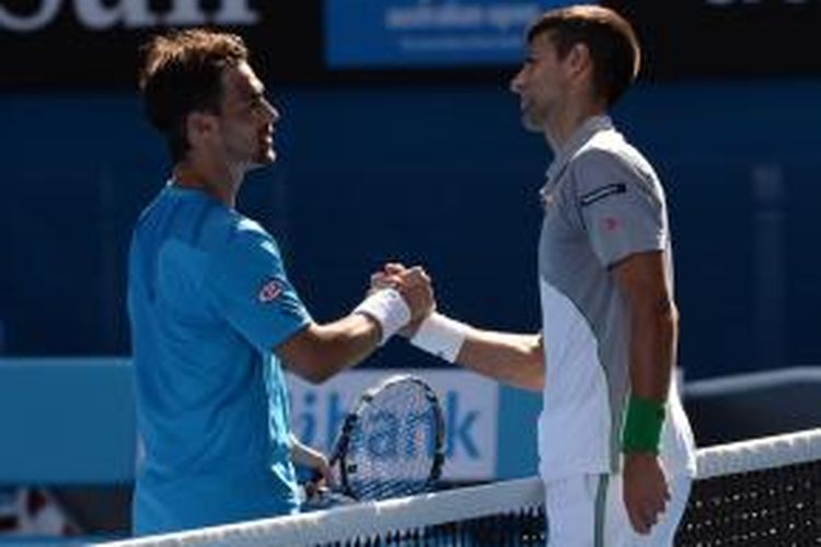 Petens Serbia, Novak Djokovic (kanan) bersalaman dengan petenis Italia, Fabio Fognini pada babak keempat Australian Open di Rod Laver Arena, Melbourne Park, Minggu (19/01/2014). Djokovic menang 6-3, 6-0, 6-2.