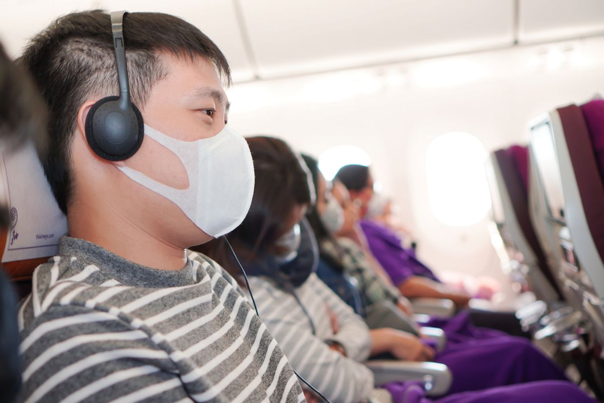 Ilustrasi penumpang menggunakan masker untuk cegah penyebaran virus corona di pesawat