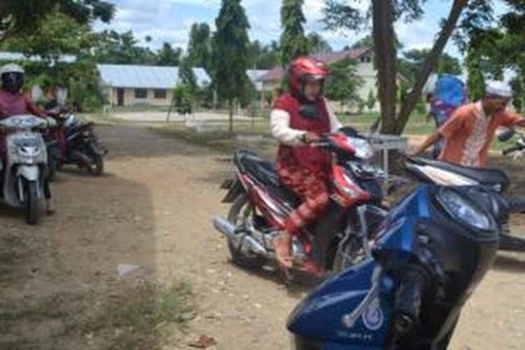 Guru SMAN 1 Langkahan meninggalkan sekolah tersebut setelah sekolah ditutup oleh komite sekolah, Jumat (21/8/2015).
