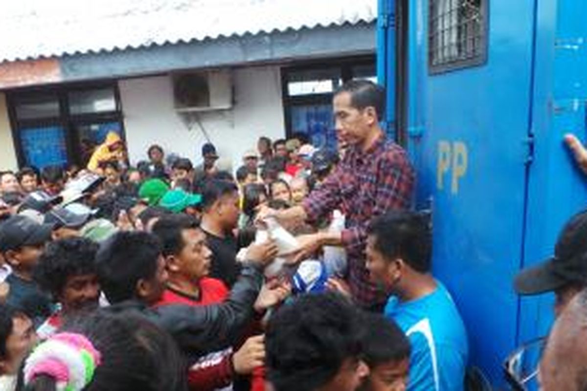 Gubernur DKI Jakarta Joko Widodo melakukan kunjungan di Kampung Nelayan, Cilincing, Jakarta Utara. Di sana Jokowi berkesempatan membagikan sembako bagi para nelayan. Minggu (2/2/2014).