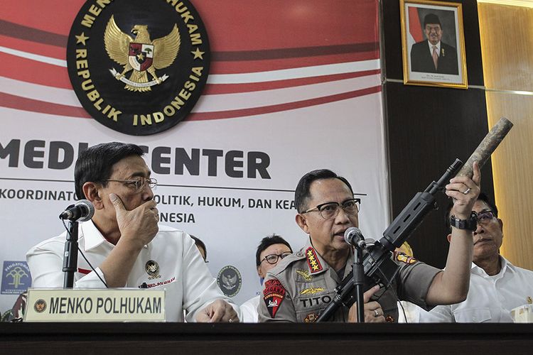 Kapolri Jenderal Pol Tito Karnavian (tengah) disaksikan Menko Polhukam Wiranto (kiri) dan Kepala KSP Moeldoko (kanan) menunjukkan barang bukti senjata api saat menyampaikan konferensi pers perkembangan pascakerusuhan di Jakarta dini hari tadi, di kantor Kemenko Polhukam, Jakarta, Rabu (22/5/2019). Menko Polhukam mengatakan Pemerintah sudah mengetahui dalang dari aksi kerusuhan yang terjadi setelah unjuk rasa di depan Bawaslu dan memastikan aparat keamanan akan menindak tegas secara hukum.