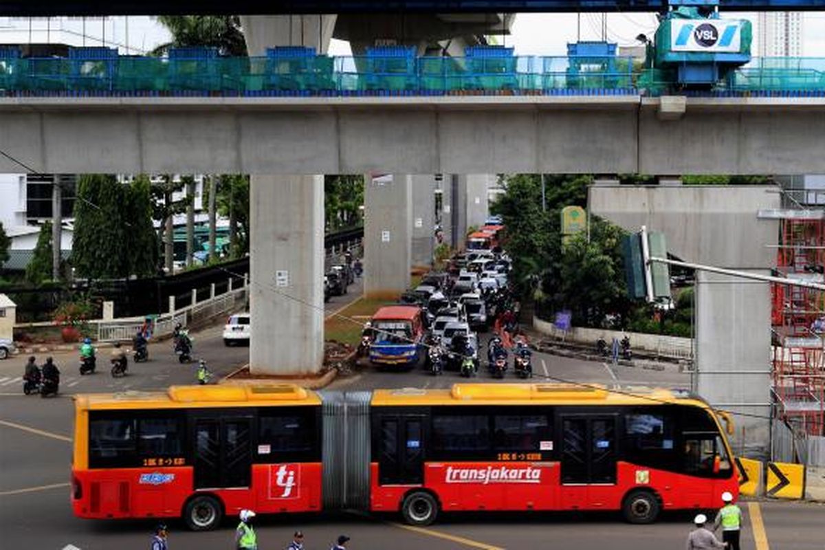 Bus transjakarta melintas di jalan Trunojoyo, Jakarta Selatan, Jumat (16/1/2017).